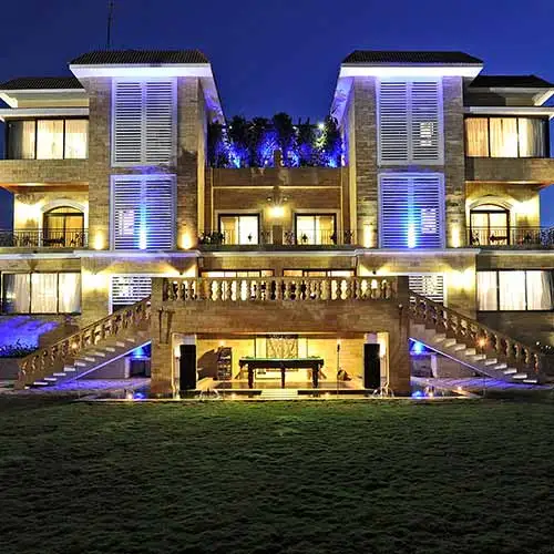Luxury villa exterior illuminated at night at Della Resorts